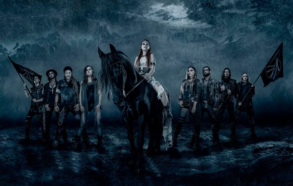 Banda Eluveitie posa para foto. Figura central é uma menina de branco montada em cavalo.