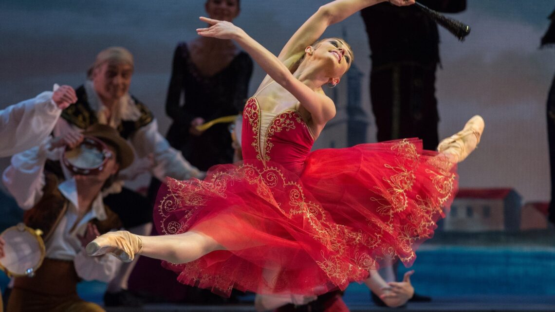 Bailarina Oksana Bondareva de vestido vermelho se apresenta