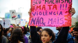 Menina segura uma faixa com dizeres contra o feminicidio