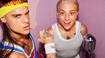 CA7RIEL & Paco Amoroso olhando para a câmera de baixo para cima em fundo rosa